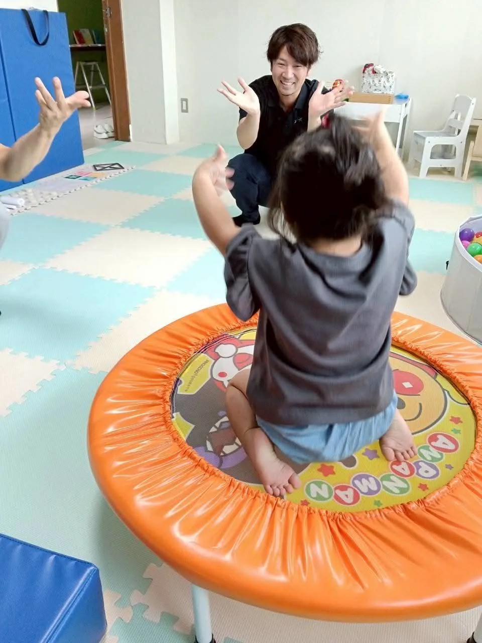 代表とトランポリンで笑顔で関わる子ども
