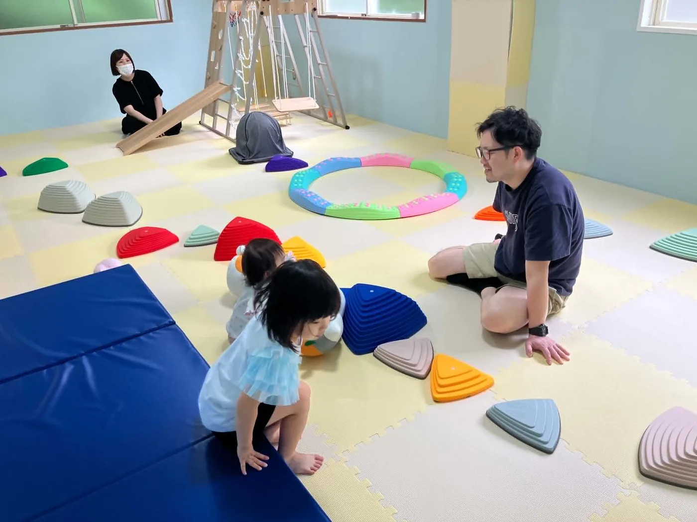 訓練室で身体を動かして遊ぶ子どもたちとスタッフ